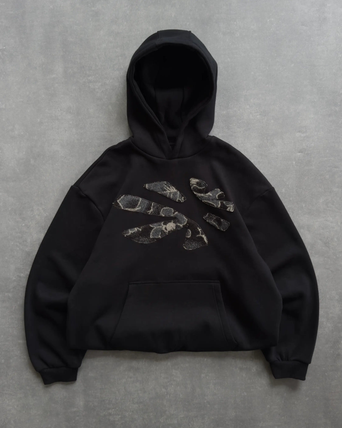 Black hoodie with graphic design on a gray background